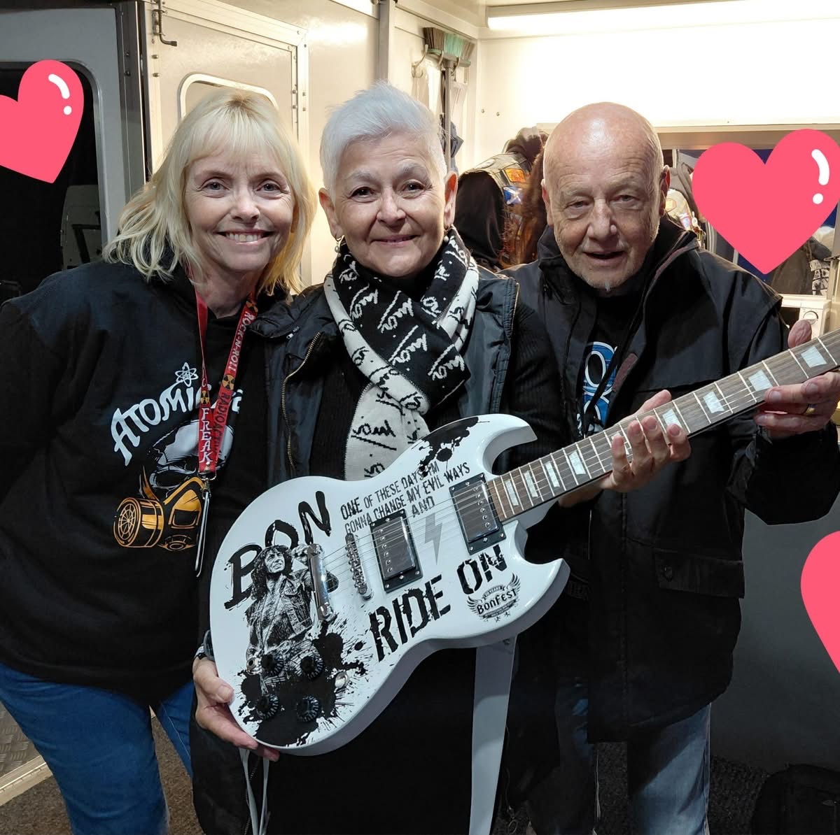 Fans holding a signed Bon Ride On guitar