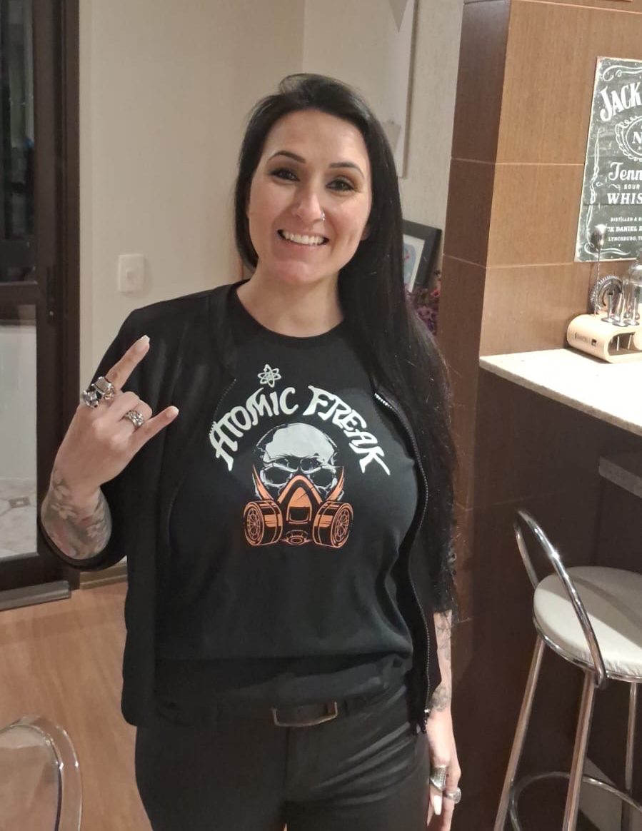 Freak Family member throwing horns in an ATOMIC FREAK skull tee
