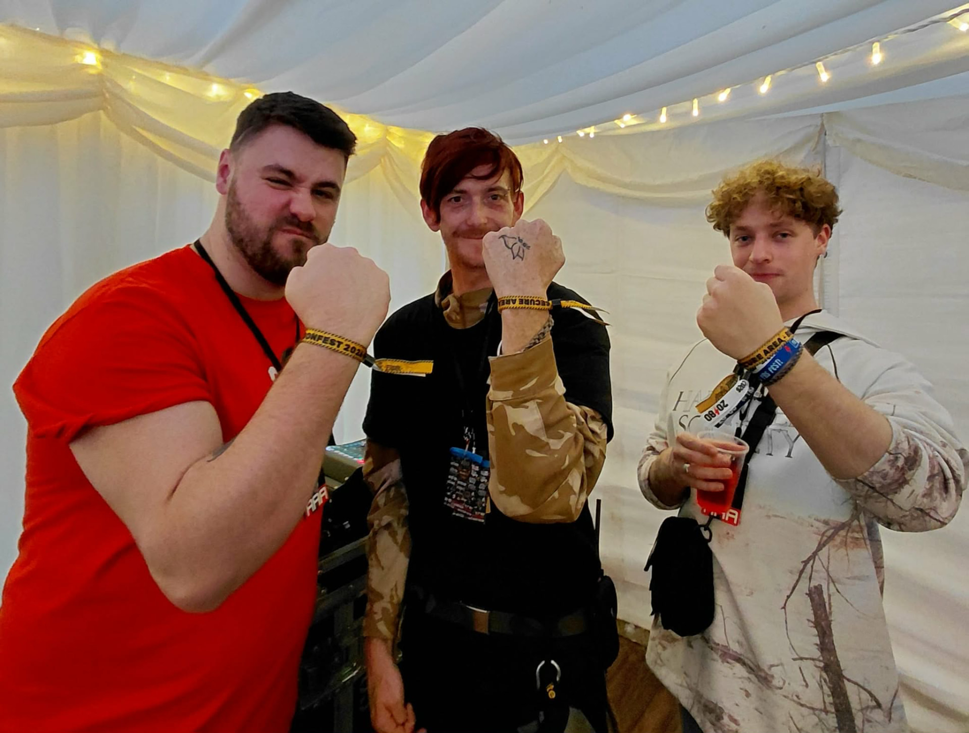 Three Freak Family members raising fists at a festival